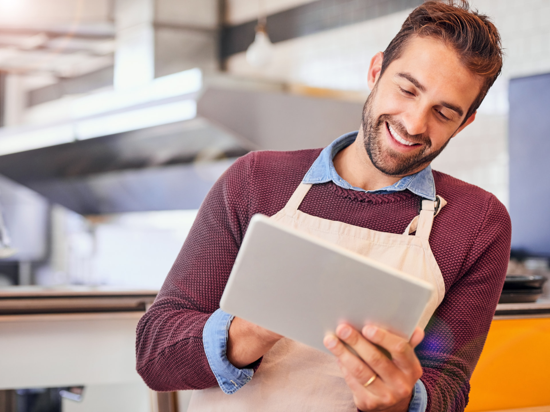 Smilende restauratør med WeFoodia på en tablet i caféen